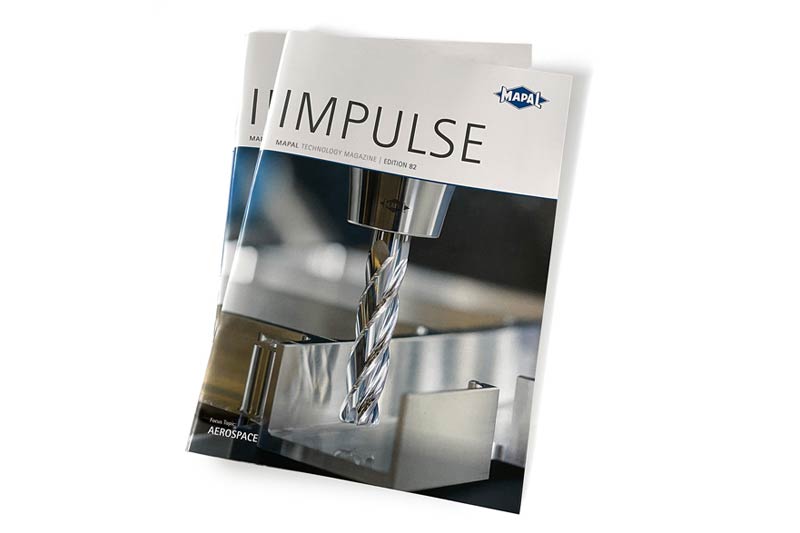 Zwei Ausgaben der deutschen Version von IMPULSE 82 von MAPAL liegen auf einem Tisch.
